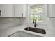 Modern kitchen sink with stylish faucet, light countertops, white subway tile backsplash, and white cabinets at 305 Gillis Rd, Roxboro, NC 27574