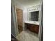 Bathroom with single sink vanity with wooden cabinets adjacent to walk-in closet at 308 Caroline Dr, Wendell, NC 27591
