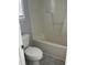 Bathroom showcasing toilet and tub with white tiling, complemented by a window at 308 Caroline Dr, Wendell, NC 27591