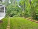 Lush green backyard with stone pathway and garden area bordered by trees at 308 Sunset Creek Cir, Chapel Hill, NC 27516