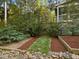 Beautiful backyard landscaping featuring an access path, mature trees and lush greenery at 308 Sunset Creek Cir, Chapel Hill, NC 27516