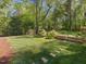 The well-manicured backyard features green lawns, stone retaining walls, mature trees, and lush landscaping at 308 Sunset Creek Cir, Chapel Hill, NC 27516