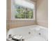 Bright bathroom featuring a tiled soaking tub and large window with exterior view at 308 Sunset Creek Cir, Chapel Hill, NC 27516