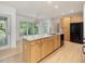 Bright kitchen features an island with bar seating, stainless steel appliances, and access to the patio at 308 Sunset Creek Cir, Chapel Hill, NC 27516