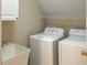 Washer and dryer set with sink, next to shelving and walls with neutral paint at 308 Sunset Creek Cir, Chapel Hill, NC 27516