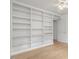 Spacious living room with a built-in floor-to-ceiling white bookshelf and hardwood floors at 308 Sunset Creek Cir, Chapel Hill, NC 27516