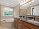 Well-lit main bathroom with a soaking tub, large double vanity, and natural light at 308 Sunset Creek Cir, Chapel Hill, NC 27516