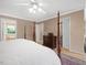View of the main bedroom featuring a four-poster bed, closet and bathroom entrances at 308 Sunset Creek Cir, Chapel Hill, NC 27516