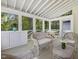 Cozy porch with beautiful view of the woods, with wicker seating and a table for entertaining at 308 Sunset Creek Cir, Chapel Hill, NC 27516