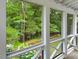 Enclosed screened porch with lattice detail overlooking a lush green backyard landscape at 308 Sunset Creek Cir, Chapel Hill, NC 27516