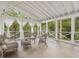 Relaxing screened porch with white-washed wicker furniture and serene views of surrounding greenery at 308 Sunset Creek Cir, Chapel Hill, NC 27516