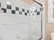 Shower enclosure with glass doors and tiled walls with black and white decorative squares at 308 Sunset Creek Cir, Chapel Hill, NC 27516