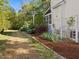 Picturesque yard with neatly mulched area, green lawn, and lush greenery bordering a home with a screened porch at 308 Sunset Creek Cir, Chapel Hill, NC 27516