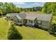 Aerial view showcasing house with landscaping, attached garage, and a backyard with mature trees at 3604 Stagecoach Rd, Durham, NC 27713