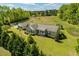 Aerial view shows the house with an attached garage, surrounded by large grass and mature trees at 3604 Stagecoach Rd, Durham, NC 27713
