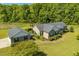 Aerial view showcases a home with an attached garage, landscaping, and surrounded by mature trees and greenery at 3604 Stagecoach Rd, Durham, NC 27713