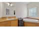 Bathroom with a soaking tub, vanity with a sink, tile flooring, and a glass block window at 3604 Stagecoach Rd, Durham, NC 27713
