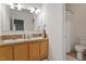 Well-lit bathroom featuring a double sink vanity, framed mirror, and a separate toilet and shower area at 3604 Stagecoach Rd, Durham, NC 27713