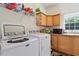 Bright laundry room featuring updated machines, ample counter space, and built-in cabinets for storage at 3604 Stagecoach Rd, Durham, NC 27713