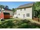 Expansive backyard featuring a verdant lawn, a charming red shed, and the home's exterior in a bright, sunny setting at 3819 Valleydale Dr, Durham, NC 27703