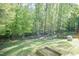 Expansive backyard with lush green lawn, mature trees, and fenced garden beds, creating a serene outdoor space at 3819 Valleydale Dr, Durham, NC 27703
