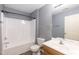 Modern blue-gray bathroom featuring vinyl floors, a shower-tub combo, single sink vanity and modern fixtures at 3819 Valleydale Dr, Durham, NC 27703