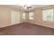 Spacious bedroom featuring a ceiling fan, double door closet, neutral colored walls and two windows with natural light at 3819 Valleydale Dr, Durham, NC 27703
