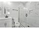 Modern bathroom showcasing a glass-enclosed shower with white marble-style tile and black hardware at 3908 Booker Ave, Durham, NC 27713