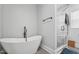 Bathroom showcasing a modern free-standing tub and glass enclosed shower with marble tiling at 3908 Booker Ave, Durham, NC 27713