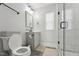 Well-lit bathroom featuring a toilet, shower with glass doors, and vanity at 3908 Booker Ave, Durham, NC 27713