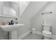 Small bathroom with a pedestal sink, toilet, and simple decor at 3908 Booker Ave, Durham, NC 27713