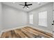 Neutral bedroom featuring hardwood floors, ceiling fan and many windows at 3908 Booker Ave, Durham, NC 27713