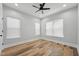 Neutral bedroom features hardwood floors, ceiling fan and many windows at 3908 Booker Ave, Durham, NC 27713