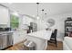 Stylish kitchen with stainless steel appliances, white cabinets, and a large window at 3908 Booker Ave, Durham, NC 27713