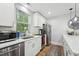 Well-lit kitchen featuring stainless steel appliances and bright white cabinetry at 3908 Booker Ave, Durham, NC 27713