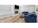 Cozy living room with hardwood floors, fireplace, television, and two blue sofas at 3908 Booker Ave, Durham, NC 27713