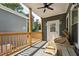 Covered porch with an exterior door, wooden railing, ceiling fan, and welcome mat at 3908 Booker Ave, Durham, NC 27713