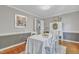 Dining room with hardwood floors, white wooden chairs, and decoratively painted accent wall at 4 W Bridlewood Trl, Durham, NC 27713