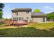 Exterior view of the home showcasing a spacious backyard, deck, and manicured lawn at 4112 Riverport Rd, Raleigh, NC 27616