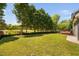 Expansive backyard featuring lush lawn, mature trees, and a wooden deck, perfect for outdoor activities and relaxation at 4112 Riverport Rd, Raleigh, NC 27616