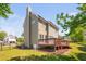 Back exterior of home featuring a deck, green grass, and partly cloudy skies at 4112 Riverport Rd, Raleigh, NC 27616