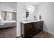 Bathroom featuring a dual sink vanity with oval mirrors, wood-look floors, and a view into the bedroom at 4112 Riverport Rd, Raleigh, NC 27616