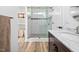 Renovated bathroom with marble counters, glass enclosed shower, and white tiled walls at 4112 Riverport Rd, Raleigh, NC 27616