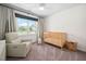 Bedroom room with wooden crib, feeding chair, neutral walls, and natural light at 4112 Riverport Rd, Raleigh, NC 27616