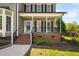 Inviting front porch with brick steps, white columns and black metal railing at 4112 Riverport Rd, Raleigh, NC 27616