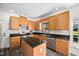 Well-lit kitchen features wood cabinets, granite countertops, an island, and stainless steel appliances at 4112 Riverport Rd, Raleigh, NC 27616