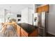 Open concept kitchen view showing island, stainless steel refrigerator, dining area and living space at 4112 Riverport Rd, Raleigh, NC 27616