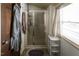 Bright bathroom featuring a stand up shower with sliding glass door, window, and neutral finishes at 481 Firetower Rd, Louisburg, NC 27549