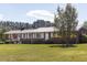 Brick ranch with large yard, white trim, metal roof, and tidy landscaping at 481 Firetower Rd, Louisburg, NC 27549
