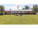 Charming brick ranch with manicured lawn, American flag, and butterfly garden at 481 Firetower Rd, Louisburg, NC 27549